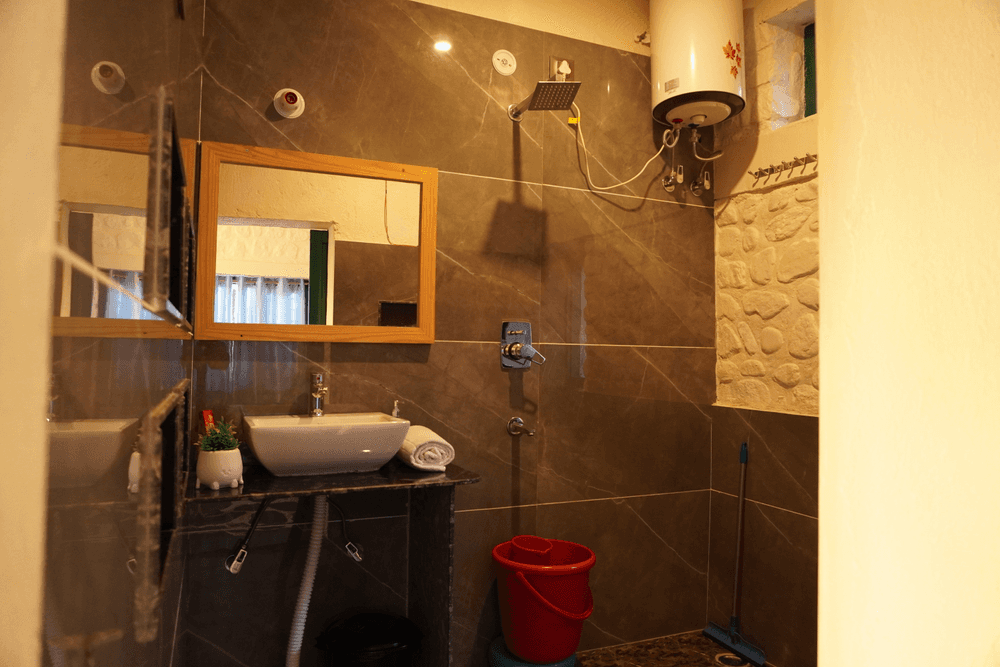 Attached bathroom with mirror, vessel basin and geyser