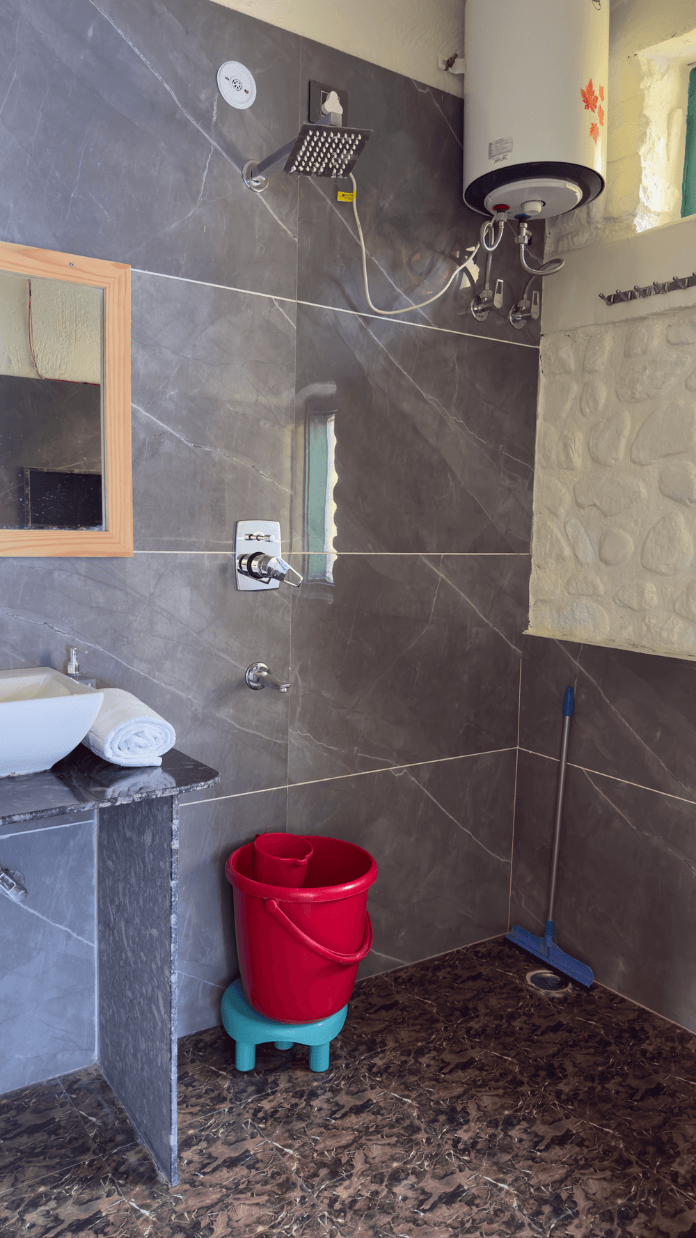 Shower with geyser and grey tiles