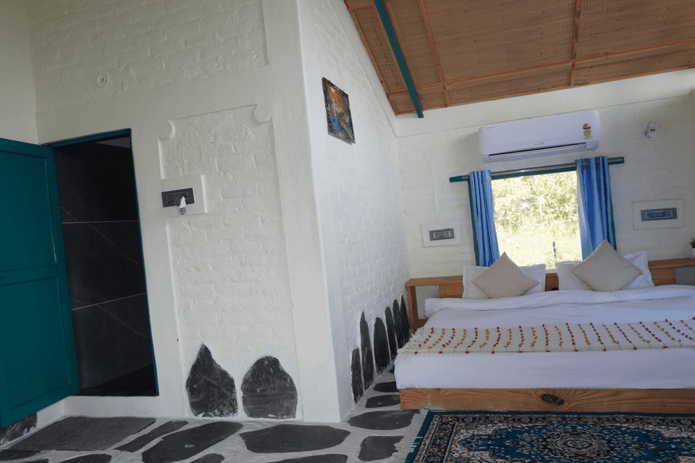 Double bed, AC and teal door to the attached bathroom