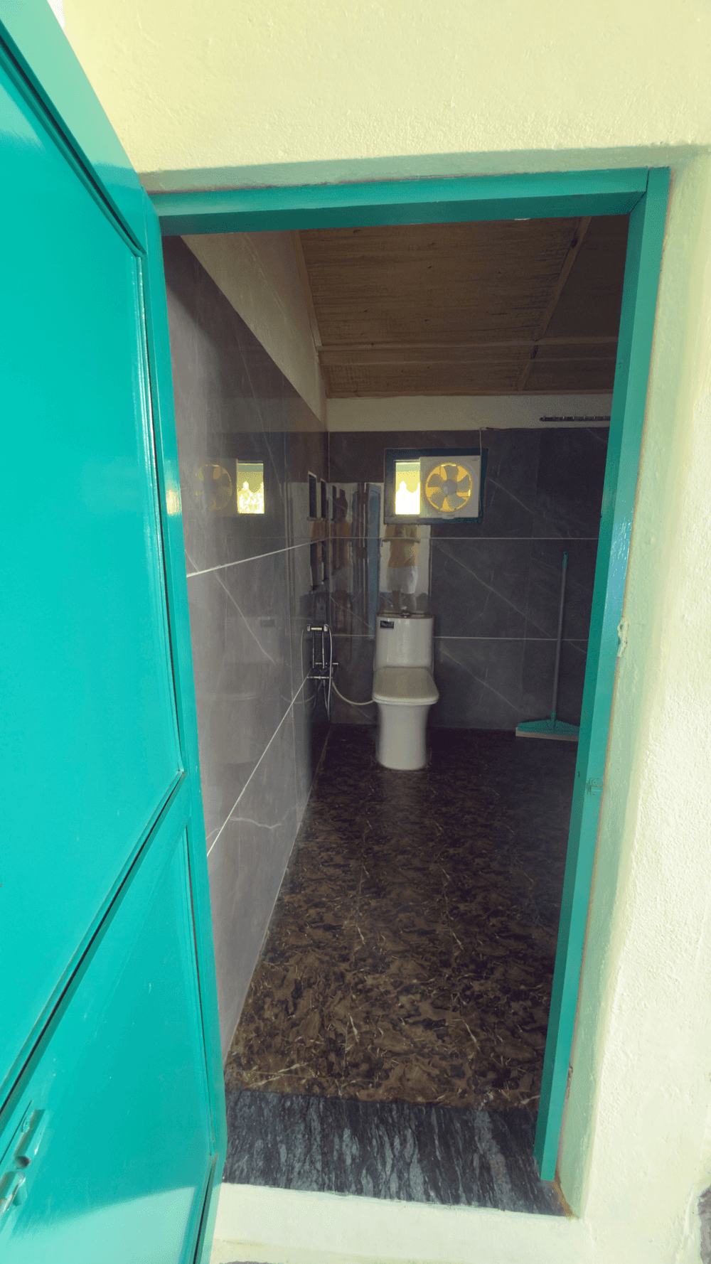 Teal door opening to the attached bathroom