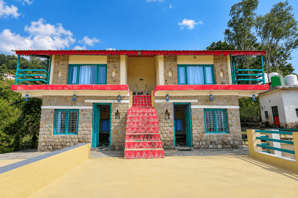 Baromasaa stone cottage with red staircase and teal doors